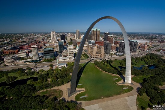 Aerial photo of a close flyby of the Gateway Arch in downtown St. Louis on a sunny, blue-sky day