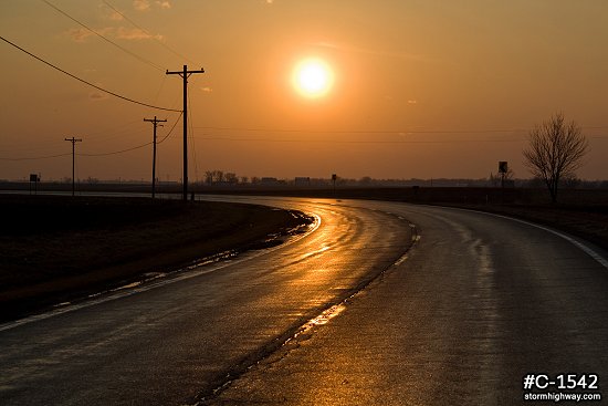Sunset over rural Illinois road after rain