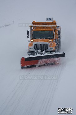 Snowplow on highway during snowstorm