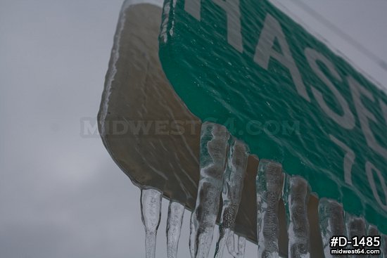 Close-up of thick icicles on street signs after an ice storm