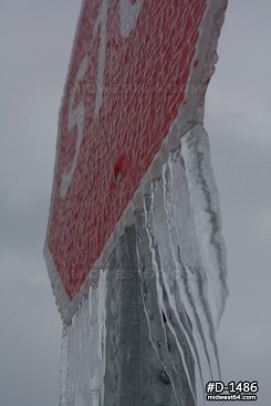 Thick icicles and ice on a stop sign after an ice storm