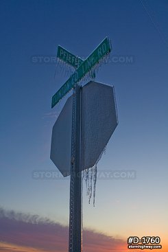 Heavy ice coating road signs with blue twilight sky after an ice storm