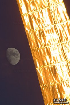 Golden sunset light reflecting in the Gateway Arch with the moon