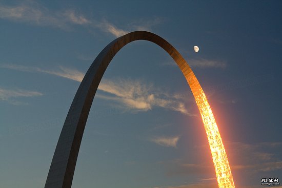 Golden sunset light reflecting in the Gateway Arch with the moon