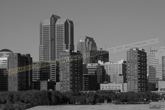 Wider view of downtown buildings in early morning sunlight with blue sky, black and white
