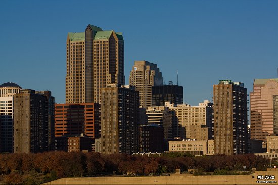 Wider view of downtown buildings in early morning sunlight with blue sky