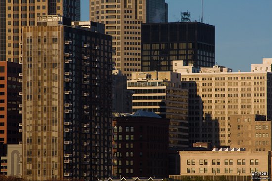Close view of downtown buildings in early morning sunlight with blue sky