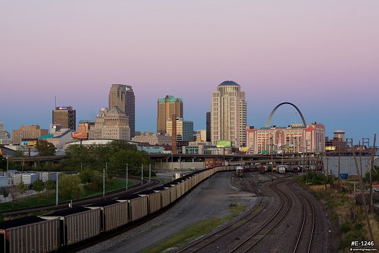 Belt of Venus accents the St. Louis skyline over railroad tracks leading into the city