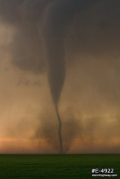 Drill-bit tornado with debris over the prairie at sunset near Rozel, Kansas