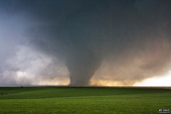 A large, strong EF4 tornado looms over green Kansas prairie near the town of Bennington