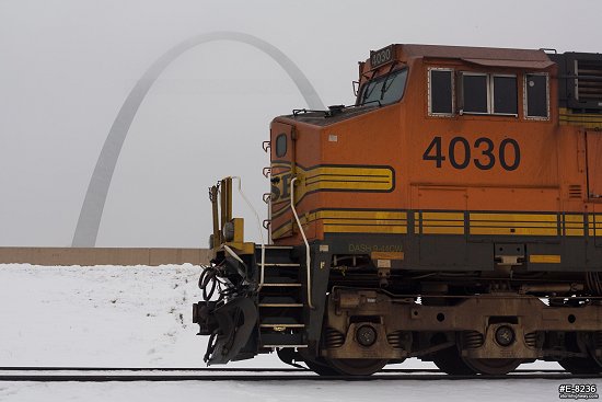 Gateway Arch in snow with a freight train locomotive.