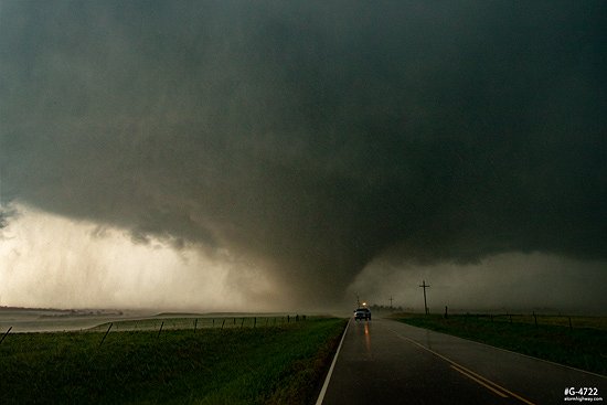 A TWIRL research group SCOUT vehicle in front of a violent long-lived EF4 tornado as it crosses a road at Abilene, Kansas