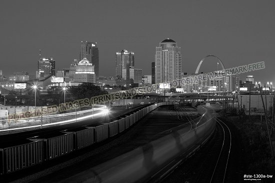 Metrolink, Union Pacific and BNSF railroad tracks with the St. Louis skyline aglow in evening twilight, black and white