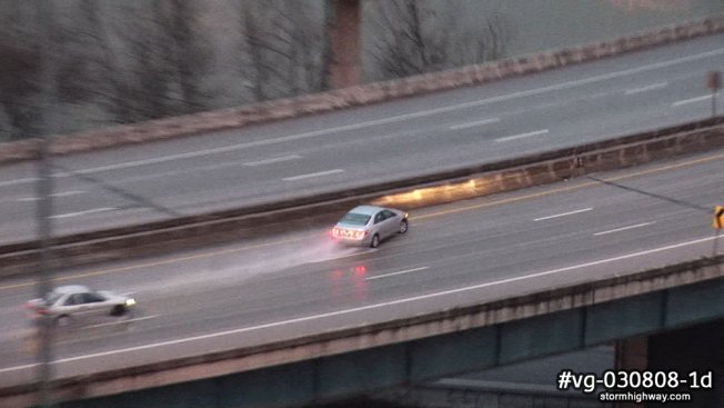 Car loses control and spins out on a freezing rain and sleet covered interstate bridge