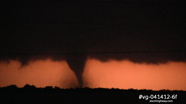 Tornado with debris illuminated by lightning at night in northwestern Oklahoma
