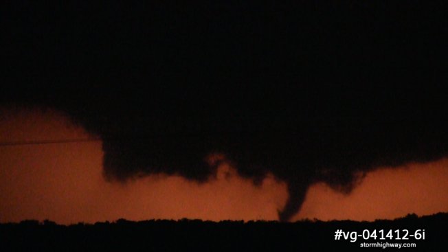 Tornado with wall cloud illuminated by lightning at night in northwestern Oklahoma