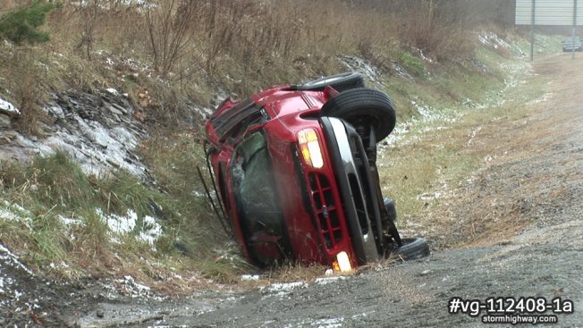 An SUV rollover aftermath along a freezing rain-coated icy interstate. 